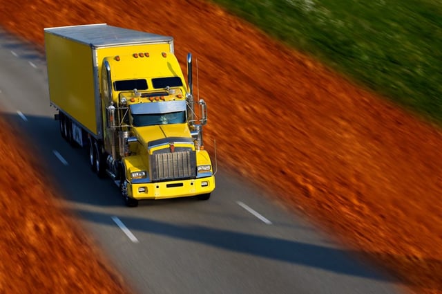 Yellow semi truck transporting goods in the trucking industry